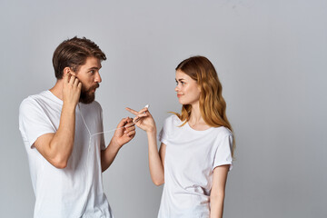 young couple in white t-shirts listening to music