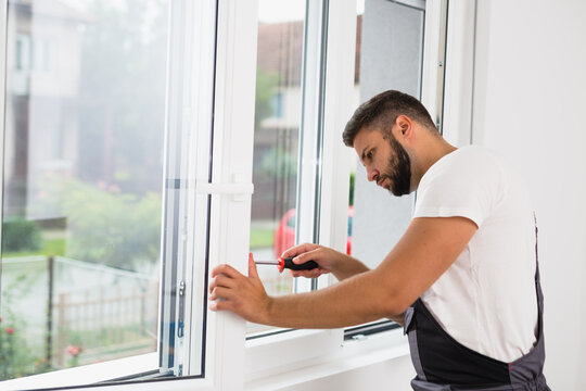 worker fixing pvc windows indoor