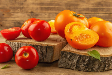 Assorted ripe tomatoes on a wooden stand. Fresh red and orange organic vegetables