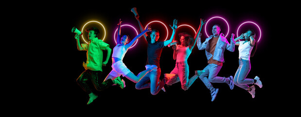 Collage made of multiethnic young people jumping together isolated on dark studio background in multicolored neon light with geometric luminescent shape cirlce