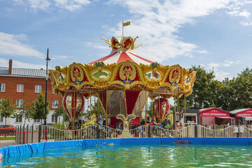 Obraz premium Bright carousel and summer pool in the amusement park on Zhitnaya square. Kolomna, Russia