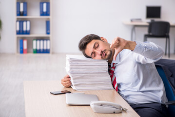 Young male employee sitting at workplace