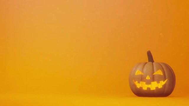Halloween pumpkin concept image. jack o lantern on a simple orange background space. Lights are blinking slowly.