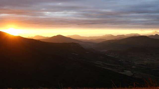 Zeitraffer des Sonnenuntergangs in der franz&ouml;sischen Region Rh&ocirc;ne-Alpes. Wolken ziehen vorbei, im Hintergrund sind Berge zu sehen.
