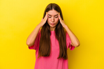 Young caucasian woman isolated on yellow background touching temples and having headache.