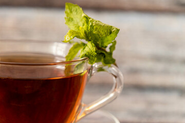 Close up shot of black tea with mint leaves on defocused background.