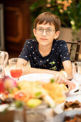 a teenage boy with glasses at the dinner table. children's menu in restaurants. 