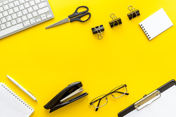 Office desk table with equipment - computer keyboard and notepad, top view