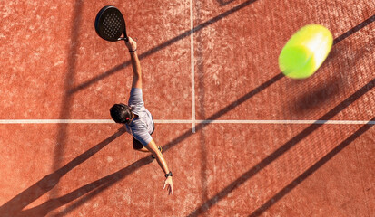 Fototapeta na wymiar View from above of a professional paddle tennis player who has just hit the ball