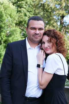 Vertical portrait of a couple in love. A Middle Eastern man in a business suit with his curly-haired wife. Happy husband and wife. Successful people, a family of businessmen.