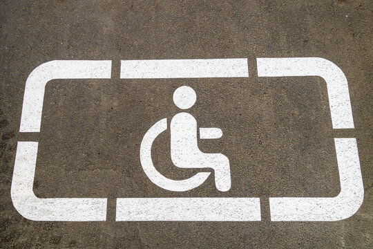 'Disabled' parking sign on asphalt background