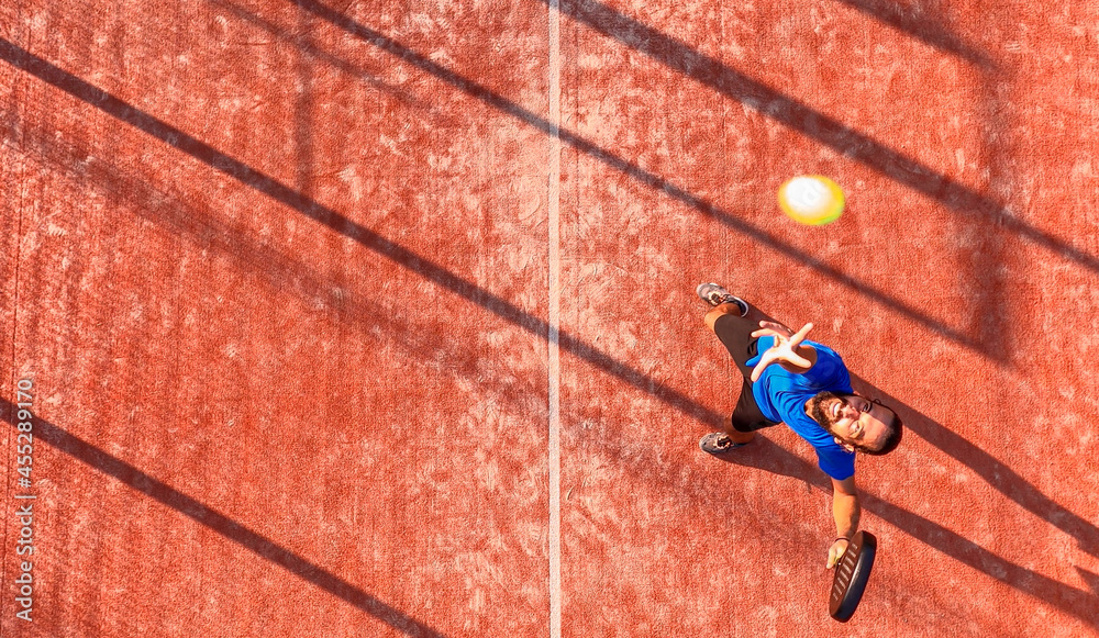 Wall mural Top view of a professional paddle tennis player who is going to hit the ball.