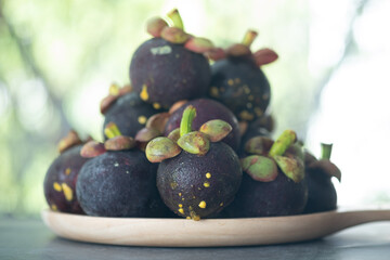 Fresh Mangosteen in the wooden dish.
