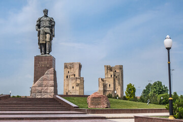 Fototapeta premium Panorama of the center of Shakhrisabz, Uzbekistan. Statue of Timur (Tamerlane), in the distance you can see the gates of the medieval palace Ak Saray