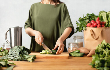 Healthy culinary concept with woman preparing fresh vegetables on her kitchen
