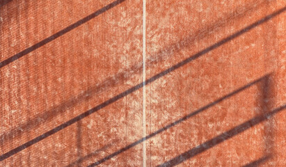 Background of an outdoor paddle tennis court seen from above. Orange court.