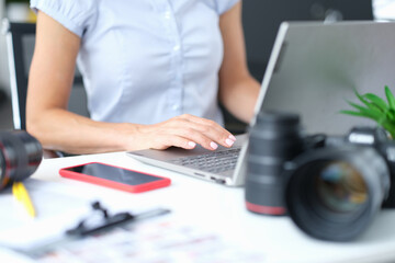 Woman works on computer next to camera closeup