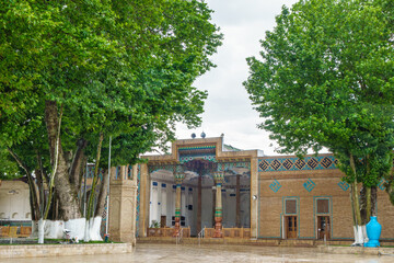 Khoja-Ahrar Mosque in Samarkand, Uzbekistan. This is a summer mosque, so the entrance to the prayer hall is open from the street. Nearby are centenary plane trees and minaret. Small rain