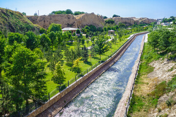 Fototapeta na wymiar City park near Afrosiyob hill in Samarkand, Uzbekistan. Siab River flows through center. Mausoleum of prophet Doniyor is visible in distance