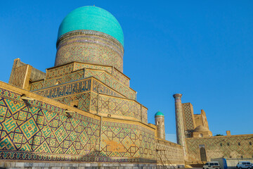 Madrasah of the Registan square in the rays of the sun against the background of a clear sky. To...