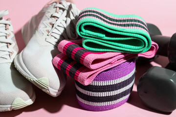 Close up of female sneakers, different resistance booty bands  and dumbbells . Essential equipment for sport workout