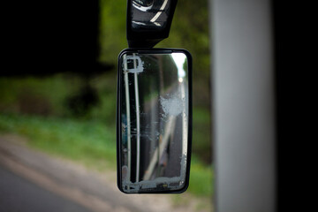 Rearview mirror by the car. Transport moves along the road.