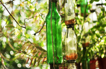 Vertical shot of old empty glass bottles in a garden