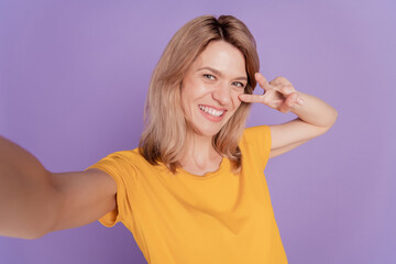 Close up photo beautiful woman happy positive smile make take selfies show peace cool v-sing isolated over purple color background