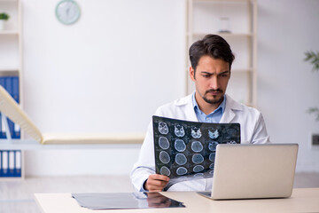 Young male doctor in wheel-chair working in the clinic