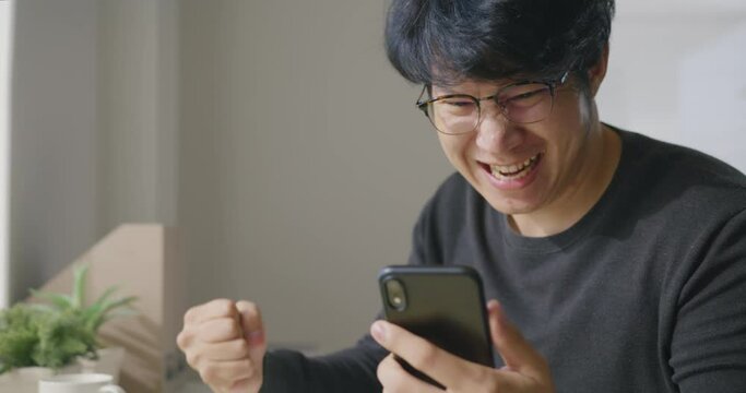 Asia man happy shock scream excited sell enjoy good news work at home office store shop read text of bank fund money approve with crazy joy, sale job win. P2P microfinance app for SME sale.