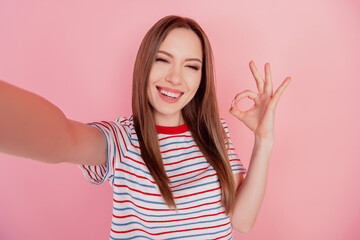 Portrait of cheerful reliable adviser lady make selfie show okey sign on pink background