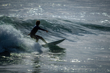 MAN SURFING WEARING WET SUIT OCEANSIDE CALIFORNIA