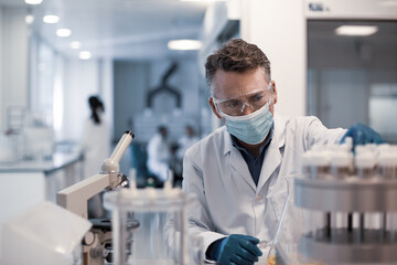Male scientist looking at test samples in a laboratory