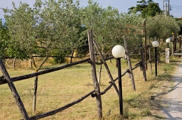 A series of street lamp near a wooden fence in the countryside (Umbria, Italy, Europe)