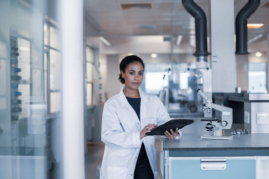 African American female scientist looking at results of experiment on a digital tablet