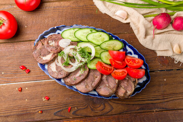 Sausage-Kazy made from horse meat with fresh vegetables on brown wooden table top view