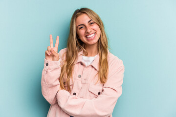 Young caucasian blonde woman isolated on blue background  showing number two with fingers.