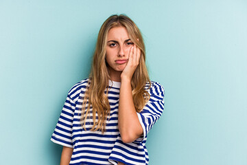 Young caucasian blonde woman isolated on blue background  who feels sad and pensive, looking at copy space.