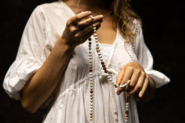 Japa mala 108 beads from natural stones. Woman's hands close up. Pray and meditation. Buddhist...