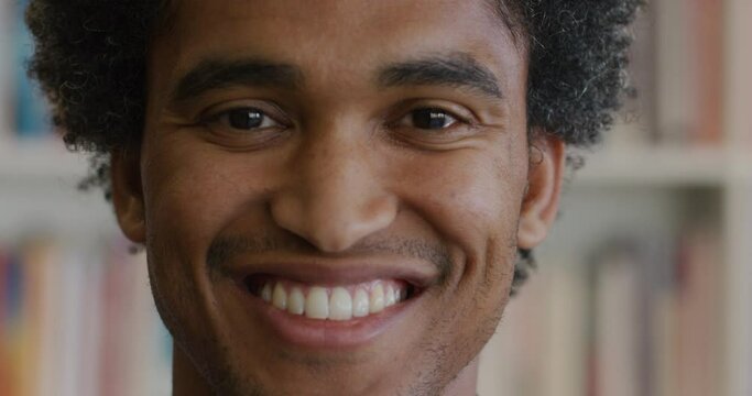 Portrait happy african american student man smiling bookshelf