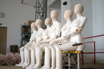 Female and male white plastic mannequins sitting on the ladder, selective focus
