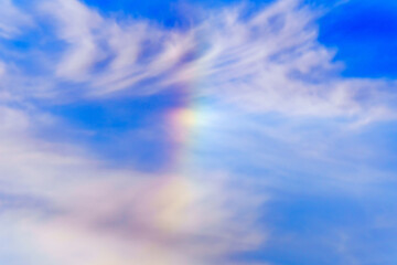 Obraz premium Rainbow on the background of a blue sky with clouds, in winter