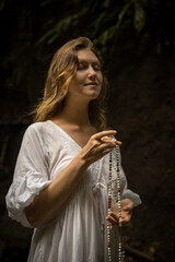 Caucasian woman keeping count during pray and meditation. Buddhist japa mala. Strands of gemstones...