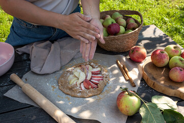 Woman making apple pie outdoors	