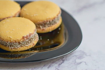 Traditional Argentinian alfajores with dulce de leche on marble table. Argentine gastronomy concept.