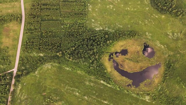 A rare lake seems to laugh slyly, aerial view, the beauty of nature. Pond with eyes and mouth. Joyful facial expression on a natural lake, top view, like in a fairy tale. UHD 4K.