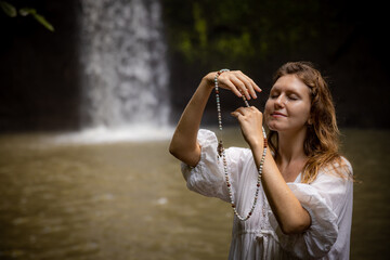 Caucasian woman keeping count during pray and meditation. Buddhist japa mala. Strands of gemstones...
