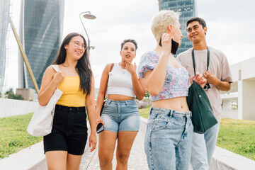 Group of multiethnic young friends outdoor having fun walking together chatting enjoying good company