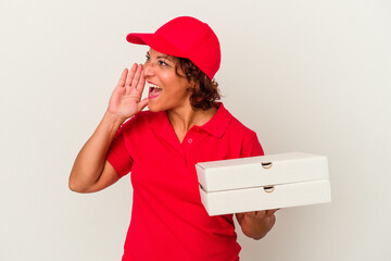 Middle age delivery woman taking pizzas isolated on white background shouting and holding palm near opened mouth.