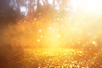 Rolgordijnen blurred abstract photo of light burst among trees and glitter golden bokeh lights © tomertu